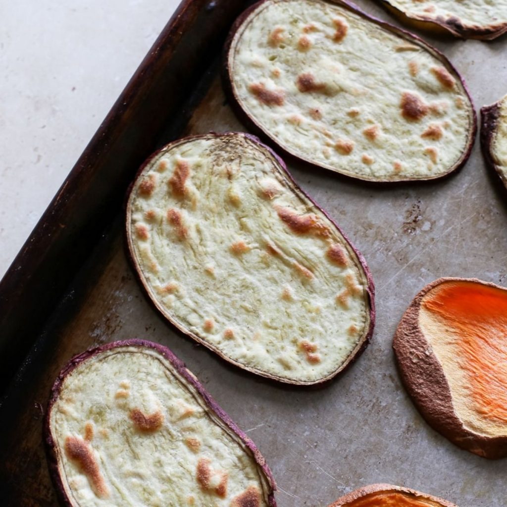 Broiled sweet potatoes toasts on a baking sheet.