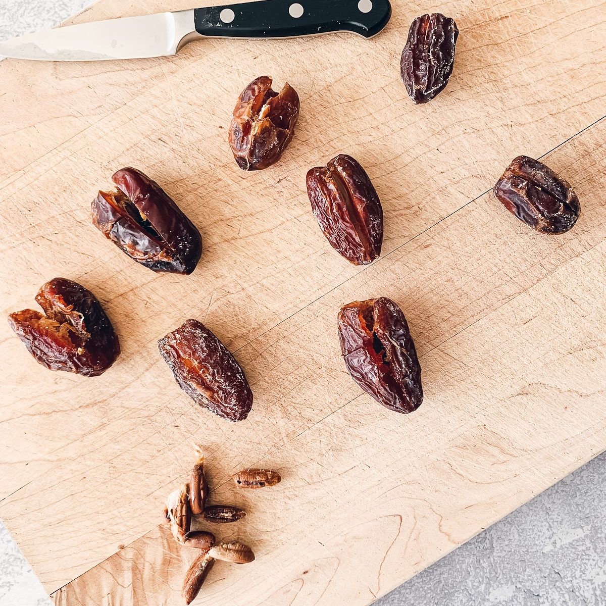 Pitted medjool dates on a cutting board.