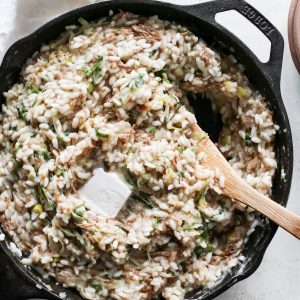 A large skillet of gluten-free dairy-free risotto with a pat of melting non-dairy butter.