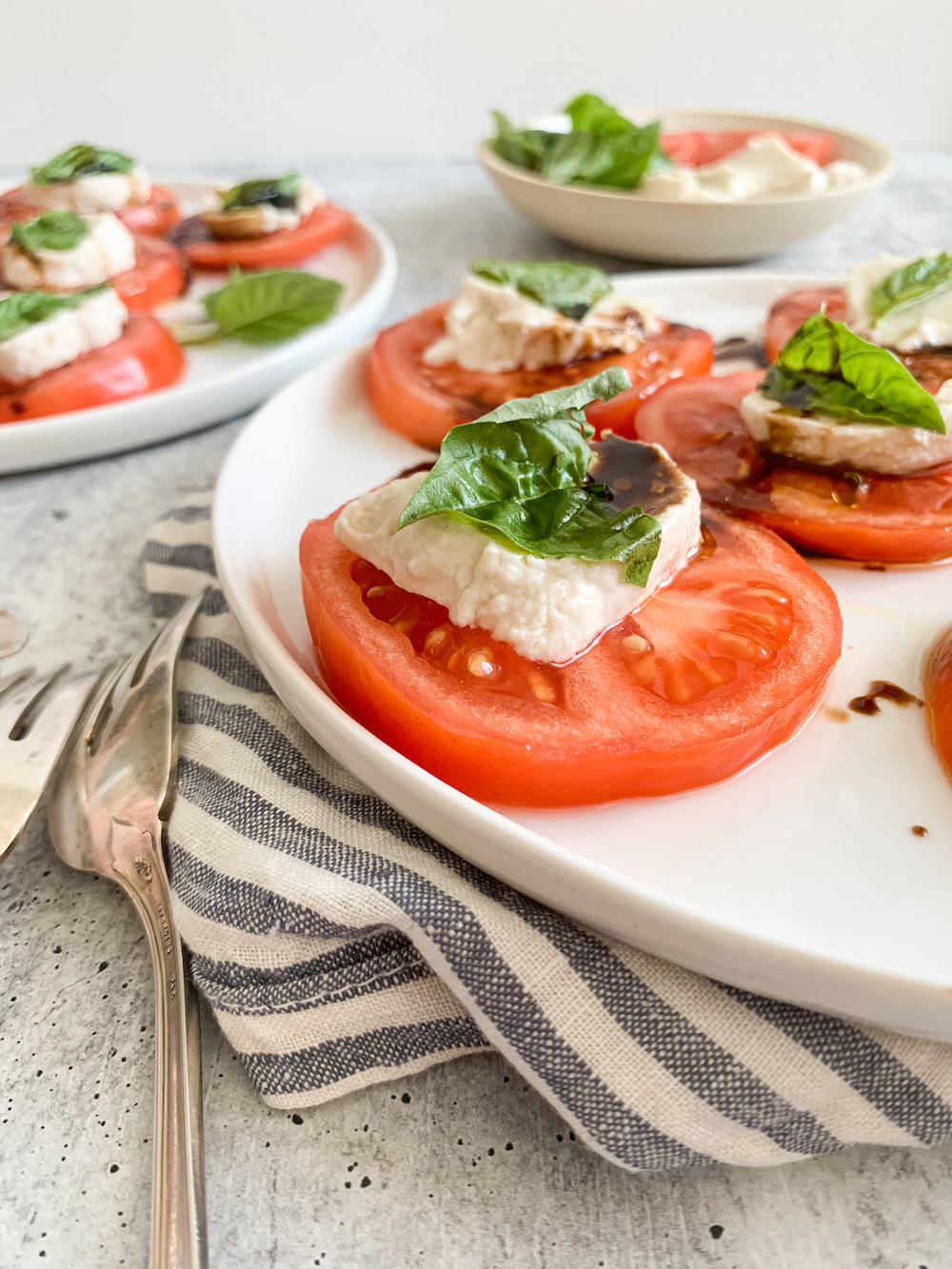 vegan mozzarella cheese on tomato slices with fresh basil