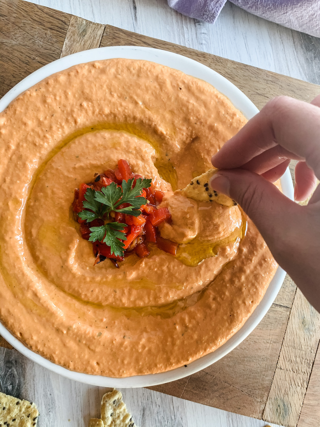 Chip Dipping into Roasted Red Pepper Hummus