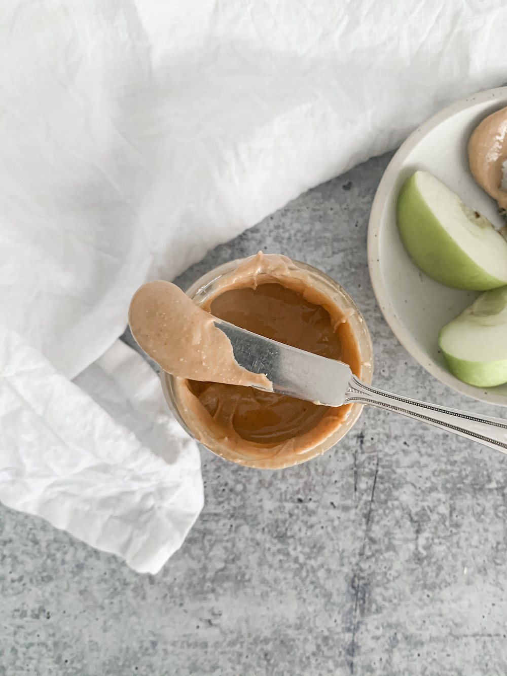 Jar of homemade cashew butter with a knife.