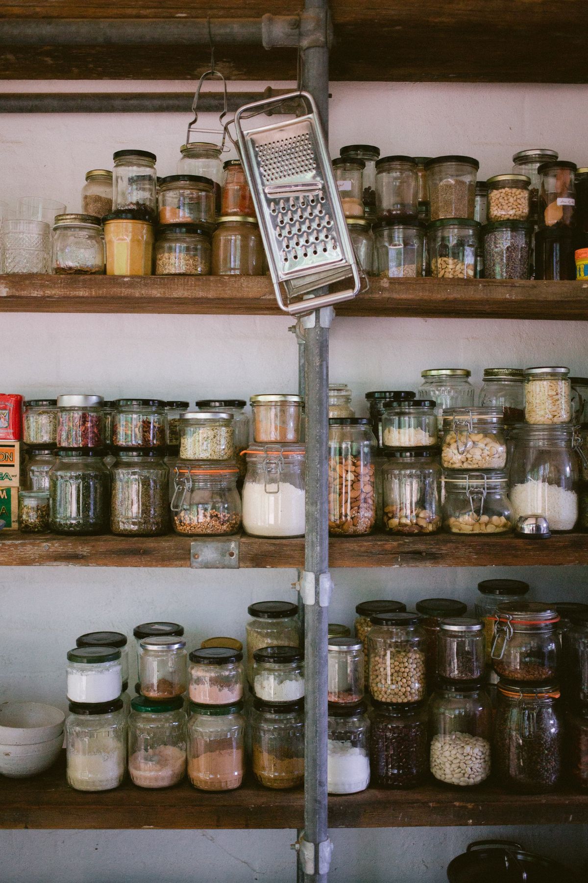 Glass jars of food on pantry shelves.