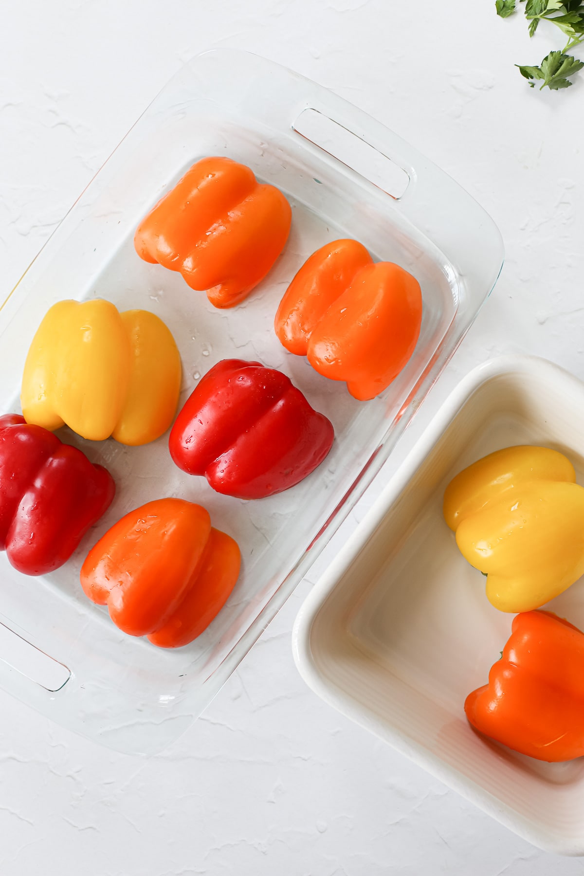 Cooked bell pepper halves in a baking pan for making dairy-free stuffed peppers.