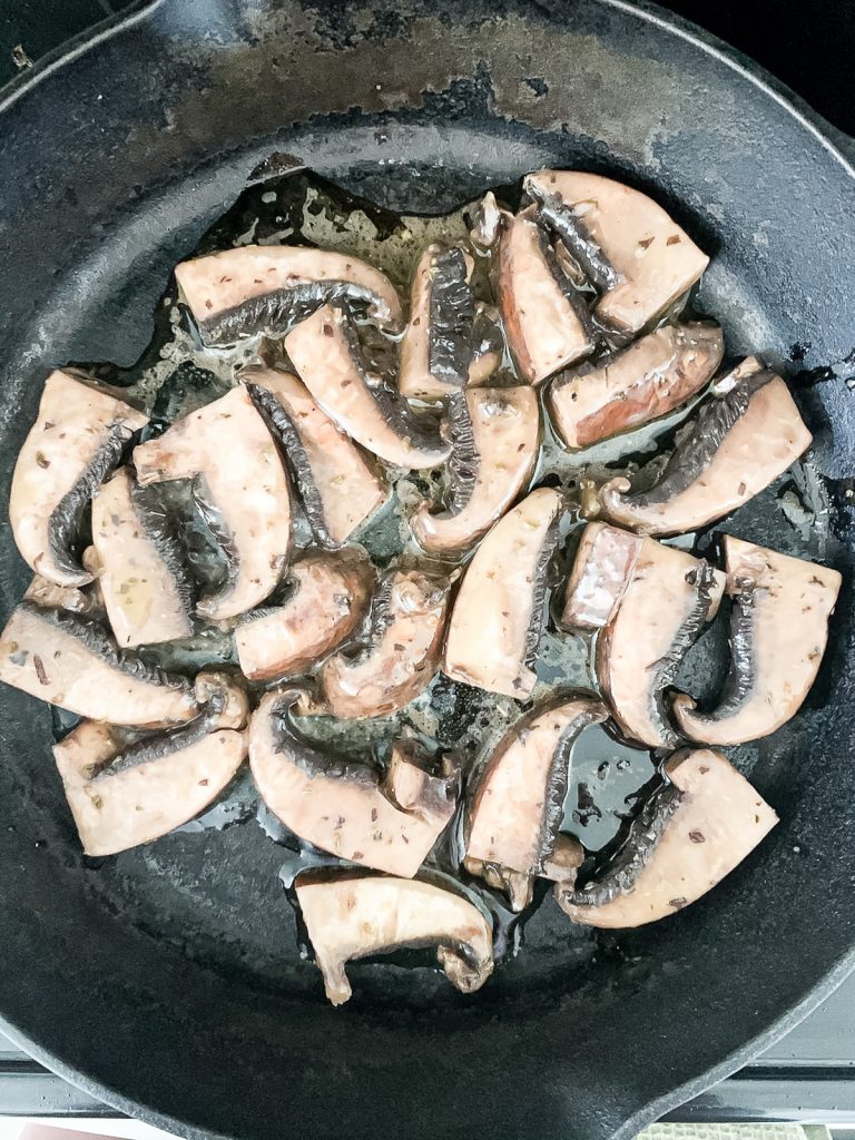 Cooking marinaded portobello mushroom slices.