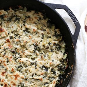 A skillet with dairy-free spinach artichoke dip inside.