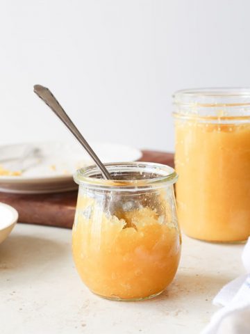 Homemade pineapple jam in jars with a spoon.