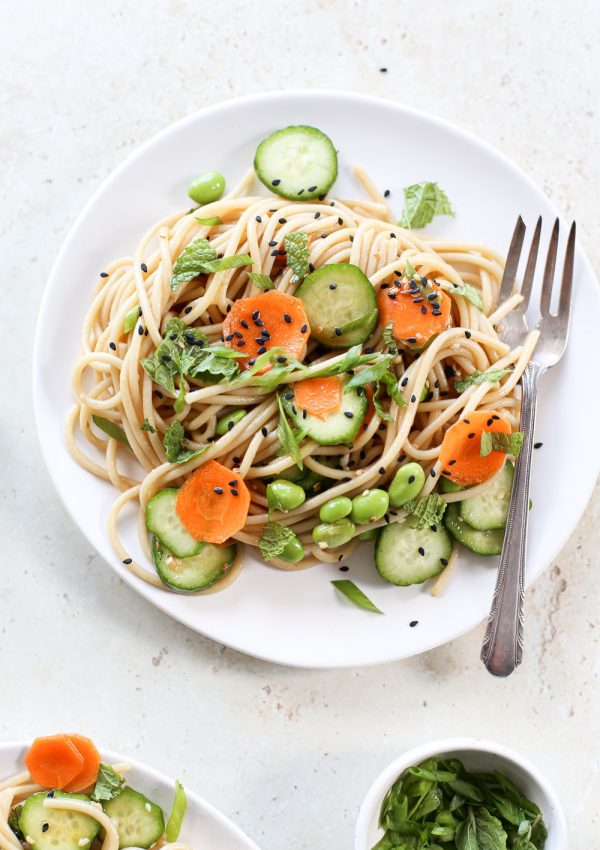Colorful plate of cold sesame noodle salad with vegetables.