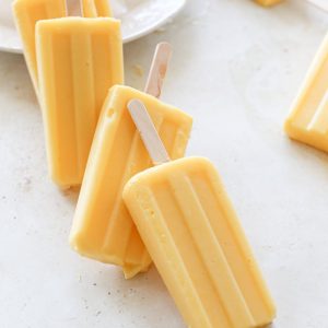 Mango pineapple popsicles overlapping in a domino effect.