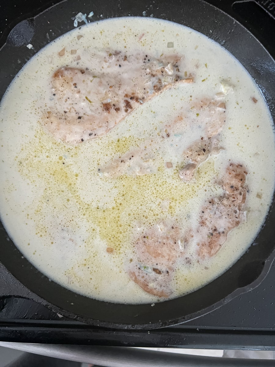 Cooking chicken in a Thai coconut lime broth sauce.