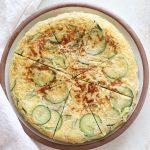 A large plate with zucchini omelette cut into slices.