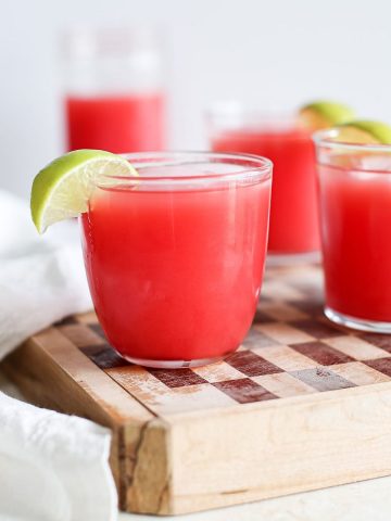 Several glasses of fresh watermelon juice served on ice.