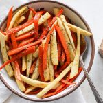 A bowl of oven roasted honey parsnips and carrots.