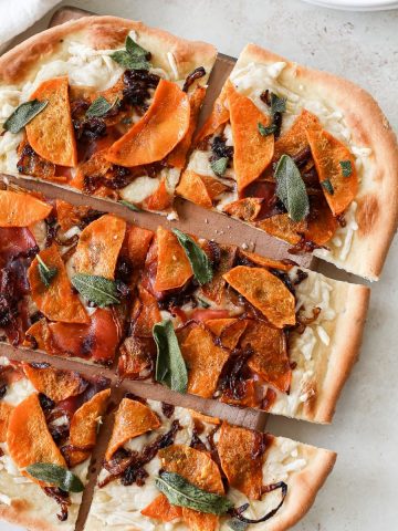 A beautiful fall-inspired pizza with butternut squash, caramelized onions, and fresh sage leaves.