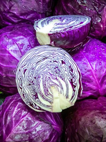 Several heads of red (or purple) cabbage with one cut in half.