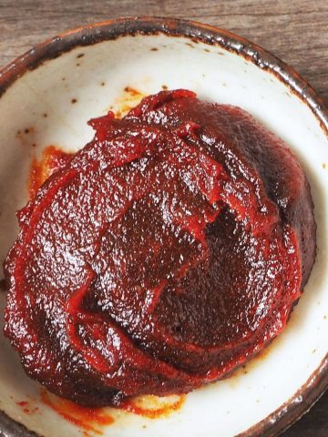 A bowl of thick, dark red gochujang paste.