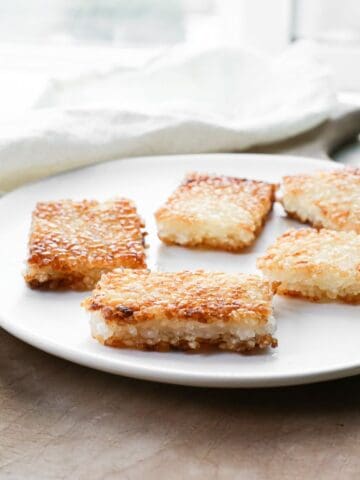 Golden brown crispy rice squares on a white plate.
